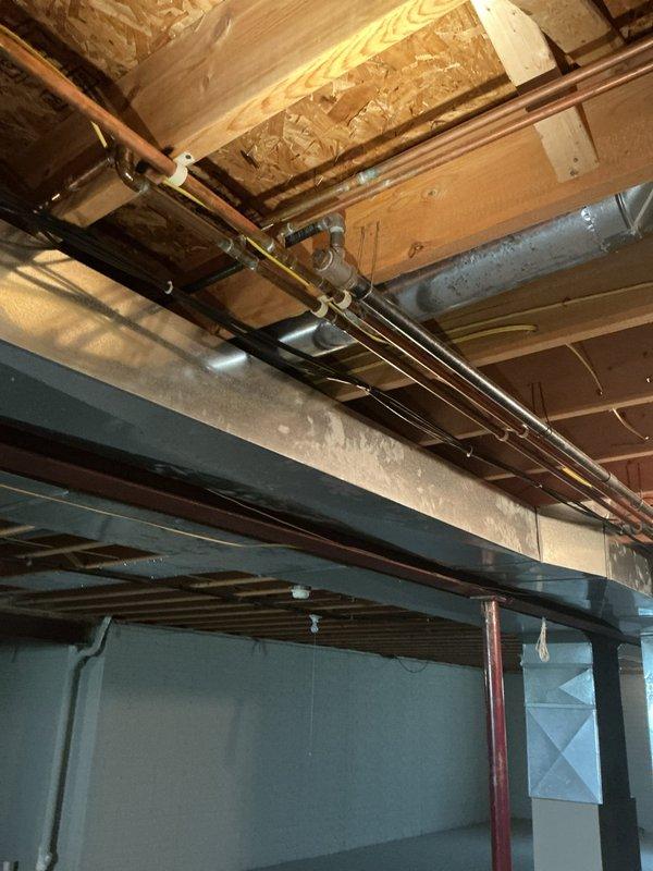 Installed new gas line to accommodate gas dryer installation in residence that previously only had electric hookup. Ran copper piping through basement ceiling joists with proper mounting brackets and support hardware to ensure secure installation and code compliance. Inspected existing natural gas meter and pressure regulator system on exterior of building, noting corrosion present on older pipe connections. Completed gas line rough-in work to prepare for dryer connection, with additional faucet replacement work to be scheduled pending availability of replacement fixtures.