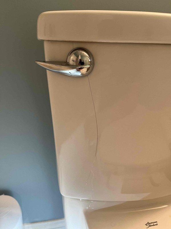 Responded to water leak originating from upstairs bathroom causing visible ceiling damage in laundry room below. Upon inspection, identified active leak source at toilet tank connection in bathroom above affected area. Documented extensive water staining and discoloration on laundry room ceiling with brownish-gray patches indicating prolonged moisture intrusion. Inspected toilet fixture including tank, flush mechanism, and supply line connections. Addressed leak at point of origin to prevent further water damage to ceiling and surrounding structures.