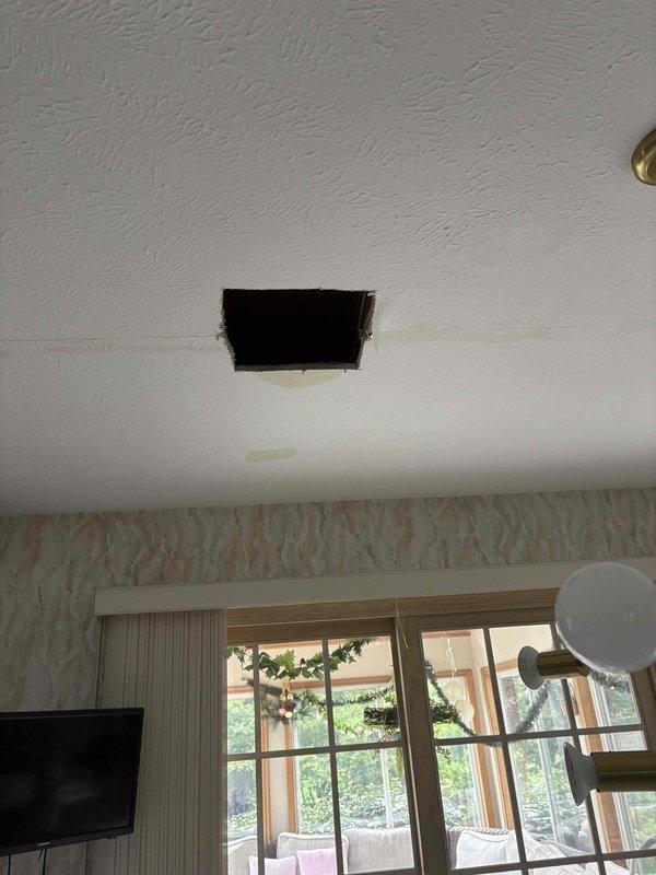 Responded to active water leak with water penetrating through ceiling from upper level bathroom. Performed initial assessment and created access opening in ceiling to investigate source and extent of water intrusion. Inspected exposed plumbing system including mixed copper and PEX piping with brass valves mounted on concrete block wall. Water infiltration continues from adjacent bathroom area. Investigation incomplete pending customer confirmation to schedule follow-up visit for comprehensive diagnosis, leak source identification, and repair quotation.