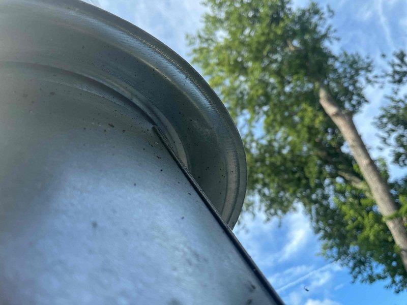 Responded to callback regarding water intrusion at roof penetration where previous ductwork modification was completed. Met with roofing contractor on-site to assess flashing integrity around PVC pipe penetration through asphalt shingle roof. Documented existing conditions with photographs showing metal flashing assembly with aluminum base plate and conical boot seal around white PVC duct penetration. Observed weathering and discoloration on flashing components and rubber gasket seal. Coordinated with roofing contractor to determine if roof-related repairs are needed and documented conditions for further review.