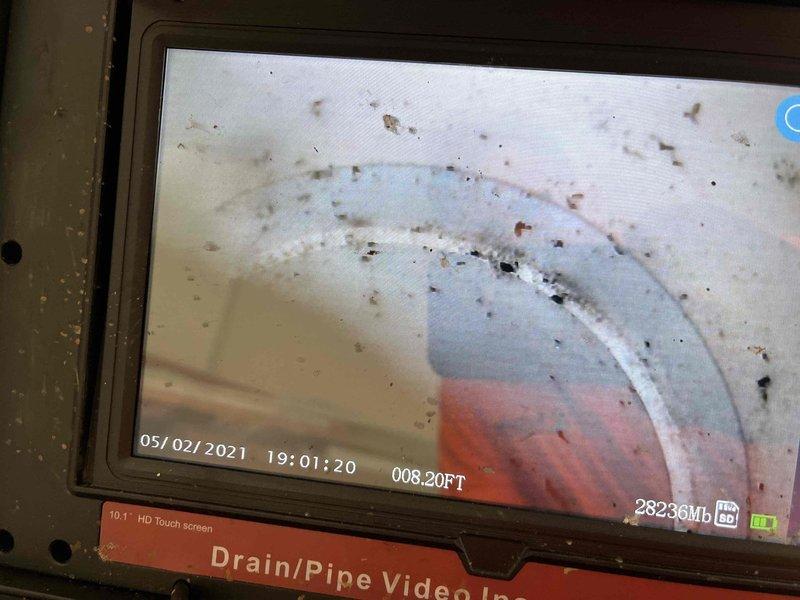 Conducted comprehensive plumbing assessment for backup power and drainage systems. Performed video inspection of interior drain lines using HD camera equipment, documenting pipe condition at 8.20 feet depth and identifying accumulated debris, staining, and sediment deposits along pipe walls. Reviewed specifications for standby generator installation, including G-Force 1000 engine with 26,000 running watts capacity, Power Zone 200 Controller, aluminum enclosure, and dual fuel capability for natural gas and liquid propane operation. Documented technical requirements including 12-volt battery system, 125-amp main line circuit breaker, fuel pressure parameters, and power consumption rates at various load percentages. Captured photographic documentation of inspection equipment and generator specifications for estimate preparation.