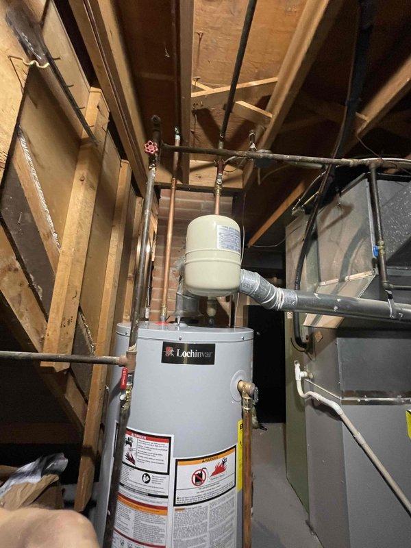 Responded to emergency call for leaking water heater in basement that required shutting off water supply to entire house to prevent flooding. Upon arrival, inspected Lochinvar gas-fired water heater and associated plumbing connections. Identified source of leak and assessed overall system condition including expansion tank, copper supply lines, and shut-off valve configuration. Replaced failed water heater with new unit, installed proper shut-off valve to allow future isolation of water heater without affecting whole-house water supply, and reconnected all gas and water lines. Verified proper burner operation and flame characteristics, checked all connections for leaks, and confirmed system functionality. Water heater restored to full operation with no active leaks detected.