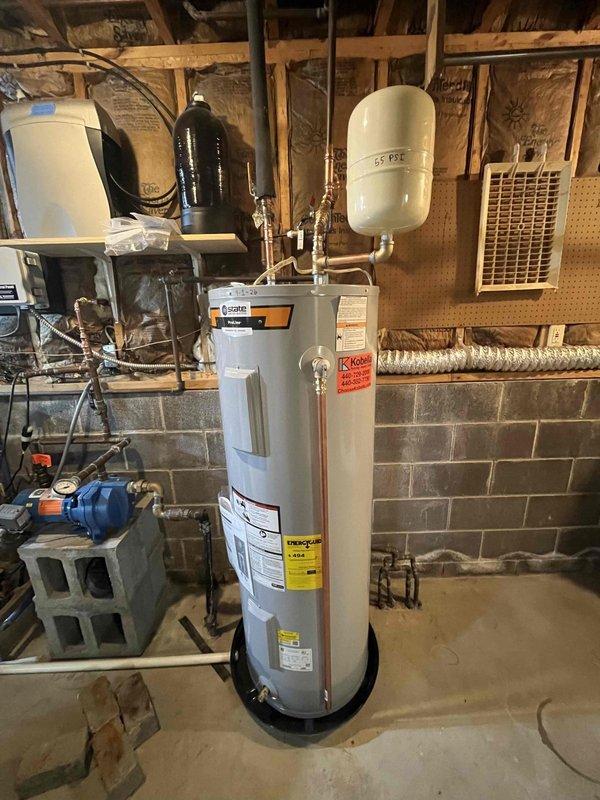 Replaced aging 12-year-old electric water heater with new 80-gallon electric unit in basement utility area. Installation included proper copper piping connections, expansion tank mounting, and installation of drain pan beneath unit as requested for leak protection. Additionally replaced outdoor hose spigot. All plumbing connections tested and verified operational with no leaks detected. System commissioned and left in full working order.