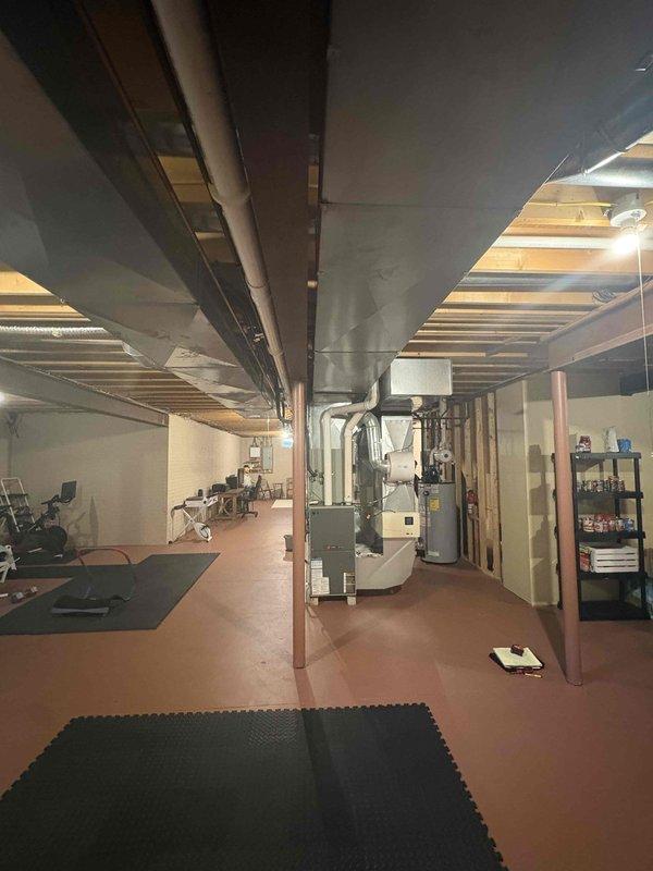Conducted comprehensive HVAC system evaluation for full system replacement estimate on dual-system residential property. Performed detailed load calculations and ductwork assessments for both System #1 and System #2, measuring supply and return trunk lines, branch configurations, and airflow requirements. Calculations determined total conditioned space of approximately 3,172 square feet including finished basement area, first floor, and second floor zones. Based on heat load analysis and square footage requirements, recommended 5-ton system with 109K BTU heating capacity to adequately serve the home. Evaluated existing ductwork configuration including return drops, supply branches, and inline duct sizing with airflow velocities ranging from 700-900 FPM. Assessed basement installation area housing current white HVAC unit with visible copper refrigerant lines and existing duct distribution system. Discussed customer interest in adding whole-home dehumidifier to improve indoor air quality