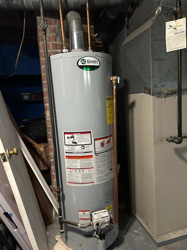 Responded to service call for leaking A.O. Smith tanked water heater approximately 10 years old. Upon inspection, confirmed active leak from unit requiring immediate attention. Instructed customer to shut off cold water supply valve to tank and run hot water taps to relieve pressure and prevent further flooding in basement utility area. Documented existing gas-fired water heater installation with photographs showing unit condition, plumbing connections, and mechanical room layout. Discussed customer's interest in converting to tankless water heater system for future consideration.