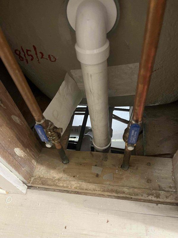 Completed repipe installation connecting branch lines back to main plumbing stack. Installed new white PVC drain and vent piping with proper securing brackets and strapping throughout basement ceiling area, including multiple horizontal branch connections with T-fittings and elbow joints. Work included routing pipes through floor framing with appropriate penetrations and clearances, alongside existing copper supply lines with shutoff valves. All connections properly secured to structural joists with code-compliant hangers and supports.