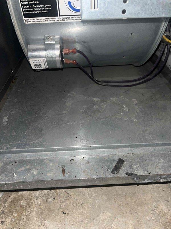 Responded to water leak concern with puddle present in front of furnace in basement location. Upon inspection, observed moisture accumulation on concrete floor near unit despite previous drain installation. Documented existing conditions including stained concrete flooring and moisture patterns indicating recurring issue. Inspected furnace interior components including blower assembly and base pan for potential leak sources. Photographed affected areas and internal components showing dust accumulation and minor debris on equipment base pan. No active leak source identified during service window, suggesting intermittent condensate drainage issue or possible overflow from existing drain system requiring monitoring and potential follow-up to determine root cause of recurring water accumulation.