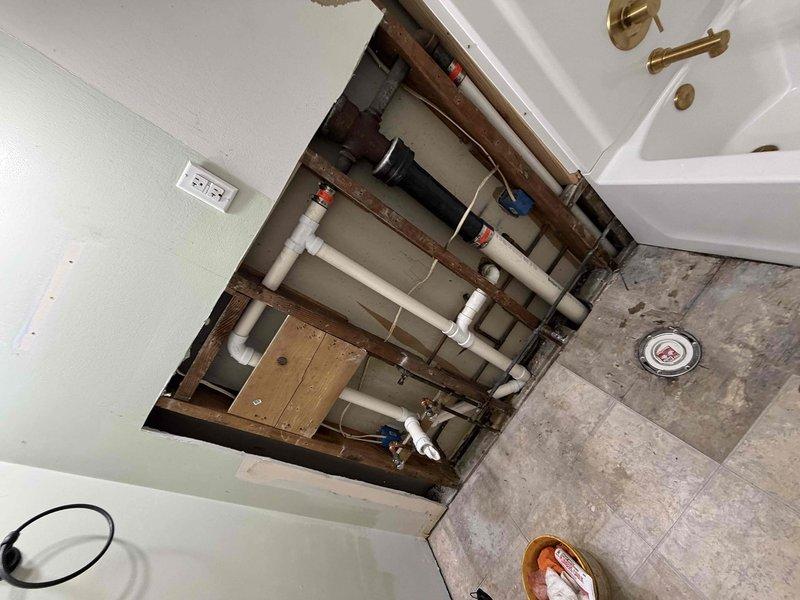 Returned to property for bathroom remodel project assessment and documentation. Inspected existing plumbing infrastructure through floor access opening, revealing network of PVC drainage and supply lines with multiple connections and fittings requiring replacement during renovation. Documented crawlspace conditions beneath bathroom showing exposed ductwork and deteriorated floor materials that will need addressing during remodel work. Confirmed snaking and camera inspection services are scheduled as part of comprehensive project scope, with all necessary materials on order and funding secured for upcoming work.