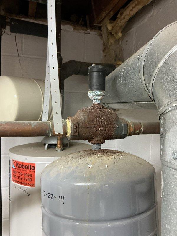 Completed annual boiler maintenance and system inspection as requested. Documented existing conditions including heavily corroded copper piping and fittings on expansion tank requiring attention, with oxidation present on connections. Verified thermostat operation and current system settings at 75°F. Captured photographic documentation of equipment conditions for service records.