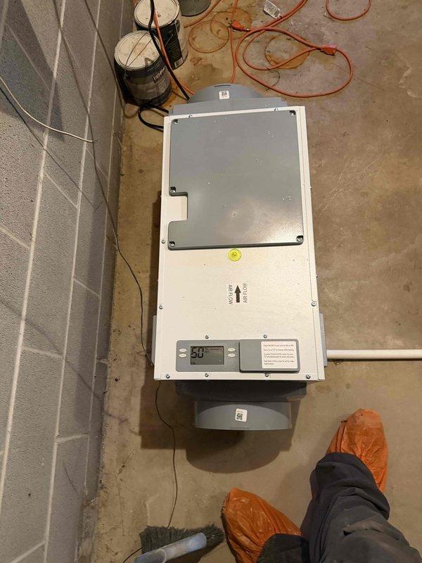 Completed installation of whole house dehumidification system with proper leveling and airflow orientation verified. Unit mounted and configured with digital controls set to 50% humidity level, all electrical connections secured, and system tested for proper operation.