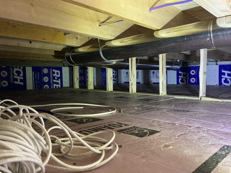 Completed ductwork installation in attic space as follow-up to previous sale. Installed black flexible ductwork with proper support hangers attached to ceiling joists, routed metallic transition ductwork through ceiling cavity with appropriate reducers and connecting joints, and installed fiberglass batt insulation between wall studs. All ductwork secured according to code requirements and system ready for HVAC connection.