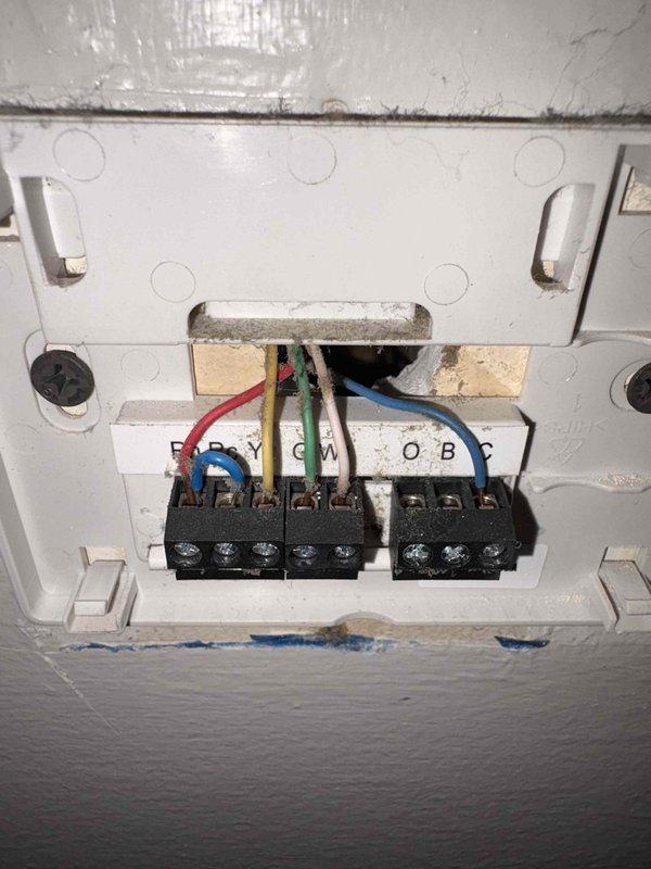 Responded to service call for HVAC system experiencing rattling sound followed by complete system failure. Upon arrival, inspected thermostat wiring and connections, documenting exposed terminal blocks and wire configuration. Evaluated full system including water heater and associated plumbing infrastructure in utility area. Provided estimate for complete system replacement due to age and condition of existing equipment.