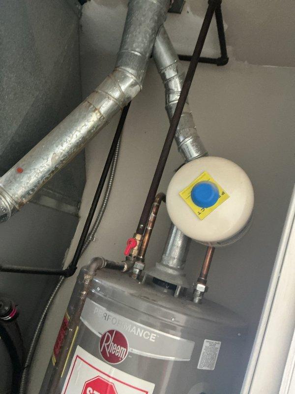 Responded to no hot water complaint on Rheem tanked water heater. Upon arrival, confirmed pilot light was extinguished and could not be relit. Inspected gas control valve assembly and observed clouded pilot sight glass, indicating potential thermocouple failure or gas valve malfunction. Evaluated existing installation including proper venting through galvanized ductwork, copper supply lines, and expansion tank. Diagnosed failed gas control valve assembly preventing pilot ignition and normal water heater operation.