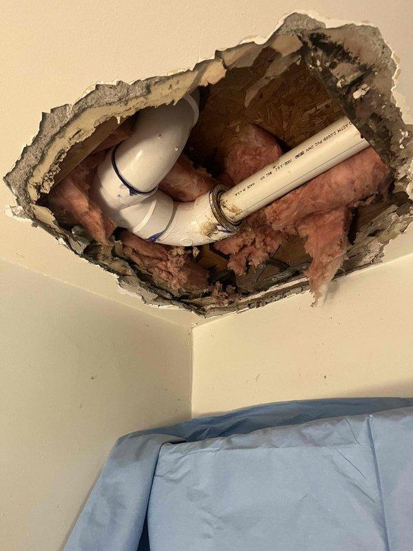 Responded to water leak in ceiling. Cut out and removed damaged drywall to expose affected area and identify leak source. Inspection revealed PVC plumbing lines above ceiling with visible moisture damage to insulation and ceiling materials, requiring structural access for proper assessment and repair of compromised plumbing components.