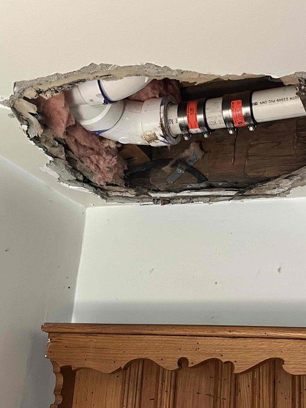 Responded to water leak in ceiling. Cut out and removed damaged drywall to expose affected area and identify leak source. Inspection revealed PVC plumbing lines above ceiling with visible moisture damage to insulation and ceiling materials, requiring structural access for proper assessment and repair of compromised plumbing components.