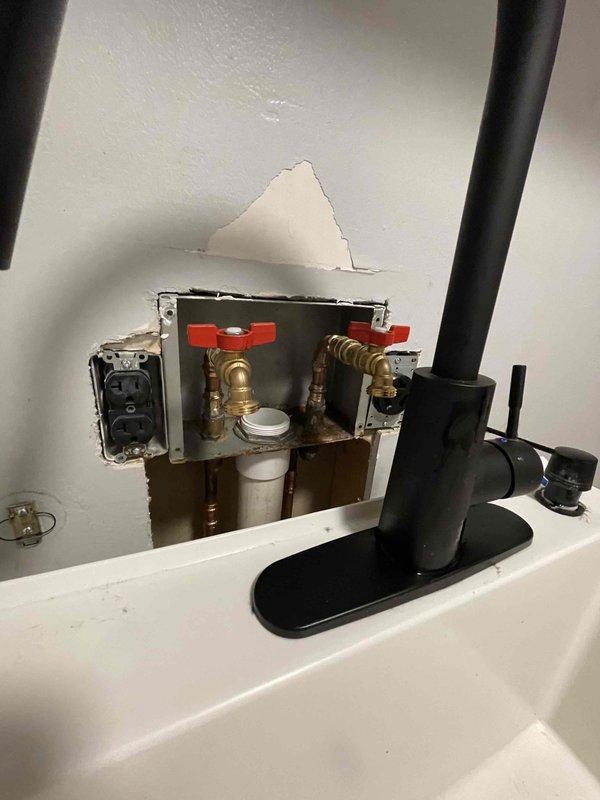 Completed re-route of laundry room water supply lines and drain system as previously sold. Accessed plumbing infrastructure through wall openings to reconfigure existing copper and PVC piping. Installed new shut-off valves with cross-handle operation and integrated water filtration system at supply connections. Rerouted vertical and horizontal drain lines using white PVC pipe with proper fittings and connections. Connected flexible supply lines to new valve configuration and verified all connections for proper water flow and drainage function.