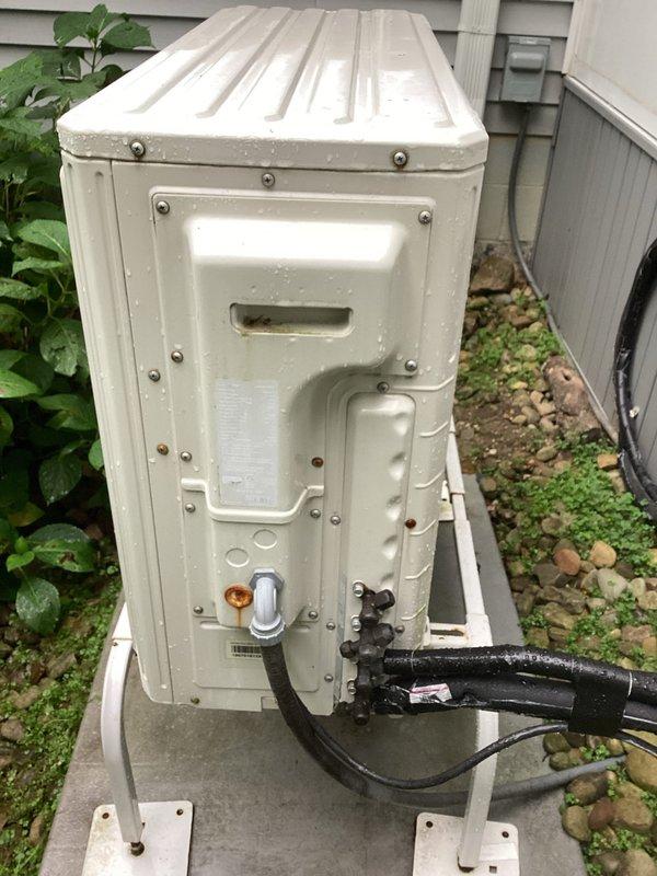 Completed estimate for replacement of 8-year-old mini-split system that had ceased cooling operation. The outdoor condensing unit showed signs of age and weathering, with visible rust staining around refrigerant line connections and discoloration on exterior surfaces. Indoor unit displayed power to the control panel but fan motor was inoperative, indicating potential compressor or control board failure requiring full system replacement evaluation.