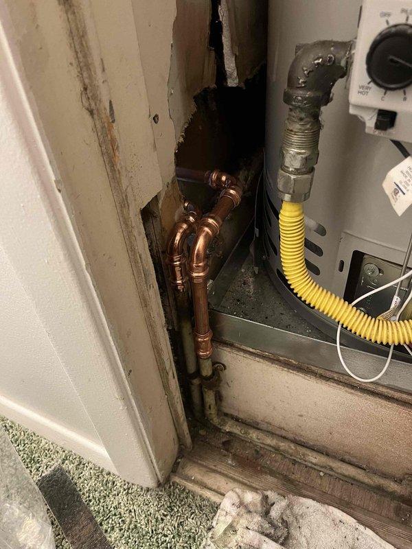 Completed follow-up repair service on Samsung top-loading washing machine water supply hoses. Inspected hose connections at wall-mounted shut-off valves with red handles, verified proper installation and secure fittings to prevent leaks, and confirmed washing machine is operating correctly with no water supply issues.