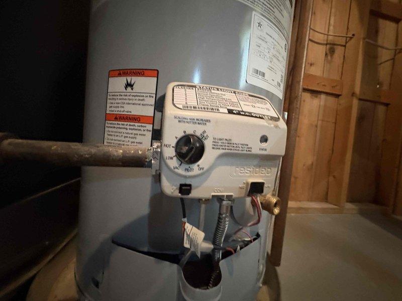 Corrected water heater venting installation on 40-gallon standard gas water heater to meet code requirements following failed home inspection. Modified and repositioned galvanized vent piping and connections to ensure proper draft and compliance with local building standards, allowing the property to pass inspection for sale.