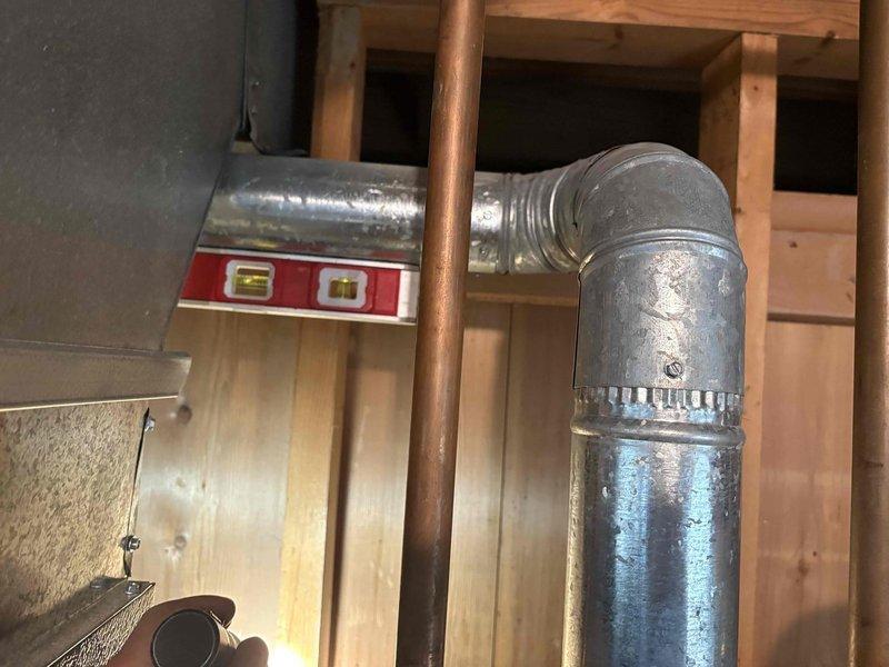 Corrected water heater venting installation on 40-gallon standard gas water heater to meet code requirements following failed home inspection. Modified and repositioned galvanized vent piping and connections to ensure proper draft and compliance with local building standards, allowing the property to pass inspection for sale.
