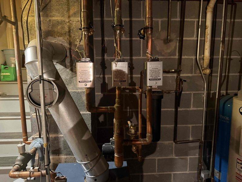 Conducted HVAC maintenance club visit and reviewed available maintenance plan options with homeowner for oil boiler heating system. Performed visual inspection of mechanical room equipment including boiler controls, zone valves, copper piping, and associated components. Documented system configuration with photos showing control relays, flow control devices, and water heater connections for service records.