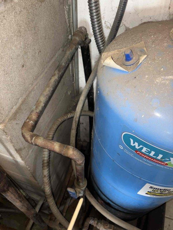 Responded to customer complaint of water softener malfunction, changes in water quality, and iron odor. Upon inspection, discovered severely corroded plumbing infrastructure including deteriorated metal pipes, aged pressure tank components, and compromised valve assemblies throughout the water treatment system. The extensive rust and corrosion on the Well-X-Trol pressure tank, connecting pipes, and control valves indicated long-term moisture exposure and system degradation affecting water softener performance. Documented existing conditions including failed pressure gauge, corroded valve mechanisms, and deteriorated copper piping. Advised customer that the iron smell and water quality issues stem from the corroded metal components leaching into the water supply, and that comprehensive system replacement of the pressure tank, valves, and associated piping is necessary to restore proper water treatment functionality and eliminate odor concerns.