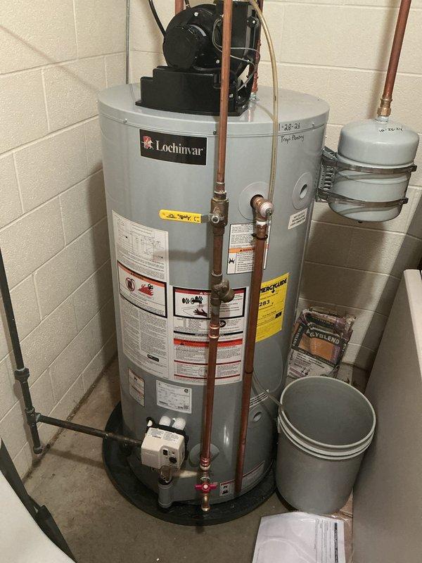 Installed new Lochinvar tanked water heater system to replace existing recirculation water heater that was causing extended wait times of up to 20 minutes for hot water delivery to remote areas of the residence. Installation included mounting of expansion tank with metal strapping, connection of copper supply and return piping with brass fittings, installation of circulator pump assembly on top of unit, and routing of PVC venting system through ceiling joists. System was pressure tested, all connections verified for proper operation, and unit commissioned to ensure adequate hot water delivery throughout the home.