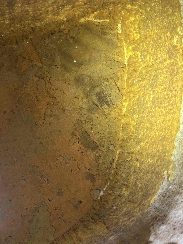 Responded to ongoing water quality concerns in a one-year-old home where previous carbon filter installation had not resolved the issue. Performed comprehensive inspection of tanked water heater and removed anode rod for examination. Found significant corrosion and degradation of the magnesium anode rod, with substantial buildup present on the rod and visible sediment accumulation inside the tank. The deteriorated anode rod was identified as the likely source of the metallic taste and discoloration in the hot water supply. Documented interior tank condition and anode rod deterioration with photographs showing mineral deposits and corrosion patterns. Recommended anode rod replacement and tank flushing to resolve water quality issues and restore proper tank protection.