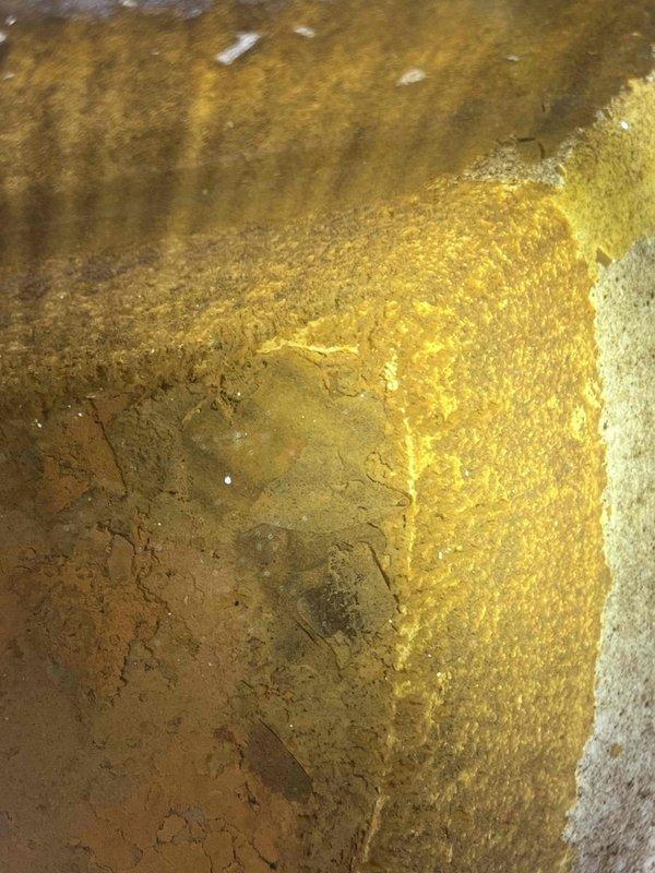 Responded to ongoing water quality concerns in a one-year-old home where previous carbon filter installation had not resolved the issue. Performed comprehensive inspection of tanked water heater and removed anode rod for examination. Found significant corrosion and degradation of the magnesium anode rod, with substantial buildup present on the rod and visible sediment accumulation inside the tank. The deteriorated anode rod was identified as the likely source of the metallic taste and discoloration in the hot water supply. Documented interior tank condition and anode rod deterioration with photographs showing mineral deposits and corrosion patterns. Recommended anode rod replacement and tank flushing to resolve water quality issues and restore proper tank protection.
