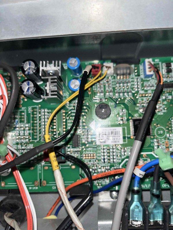Responded to recurring E9 error code on mini split system. Accessed and inspected main control board PCB, documenting component condition and wiring connections. E9 fault typically indicates communication error between indoor and outdoor units or control board malfunction. Photographed circuit board assembly showing capacitors, integrated circuits, heat sinks, and multi-conductor wiring harness for diagnostic reference. Recommended escalation to senior technician for advanced troubleshooting of intermittent electronic fault.