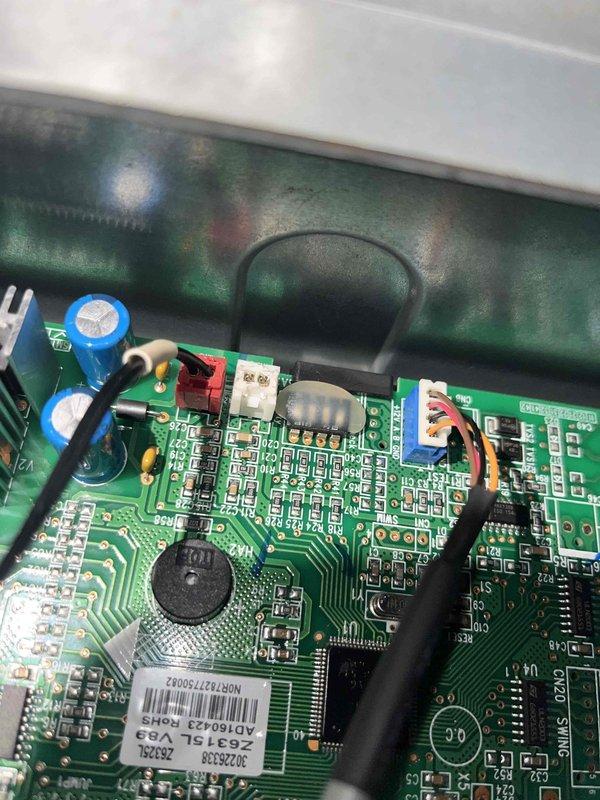 Responded to recurring E9 error code on mini split system. Accessed and inspected main control board PCB, documenting component condition and wiring connections. E9 fault typically indicates communication error between indoor and outdoor units or control board malfunction. Photographed circuit board assembly showing capacitors, integrated circuits, heat sinks, and multi-conductor wiring harness for diagnostic reference. Recommended escalation to senior technician for advanced troubleshooting of intermittent electronic fault.