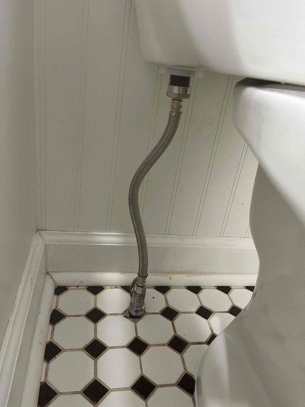 Responded to report of water leaking into basement during toilet flushing. Upon inspection, identified compromised toilet seal or flange connection allowing water to bypass the drainage system. Examined toilet installation, water supply line, and floor-mounted shut-off valve. Documented existing conditions including flexible braided supply line connection and octagonal tile flooring for service records.