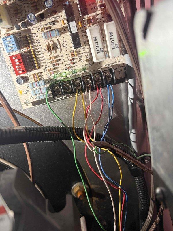 Returned to complete fan motor replacement on HVAC system, with materials ordered from supplier and expected delivery confirmed. Inspected thermostat wiring and control board connections to address customer inquiry regarding heat pump auxiliary heating operation for winter oil consumption reduction. Verified thermostat configuration and documented existing wiring at both the air handler control board and wall thermostat, preparing system for proper heat pump operation with auxiliary heat functionality once replacement motor is installed.