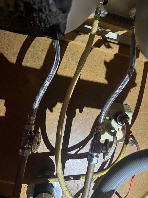 Responded to water leak under kitchen sink. Upon inspection, identified fine mist spray originating from plumbing connections at the shut-off valve assembly. Tightened braided supply line fittings and chrome-plated valve connections to eliminate leak. Verified all connections were secure and tested system under pressure to confirm repair was successful with no further water discharge detected.