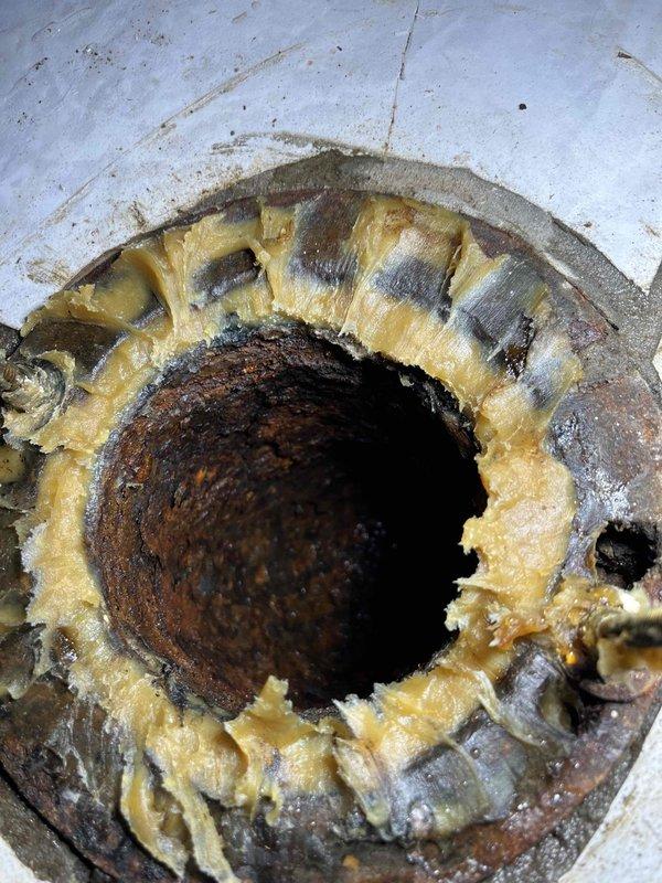 Responded to toilet leak at base of fixture. Previous wax ring replacement by homeowner did not resolve issue. Upon inspection, discovered severely corroded and deteriorated toilet flange with compromised mounting surface. Removed toilet, confirmed flange damage preventing proper seal. Installed new toilet flange repair kit and replacement wax ring with proper compression. Reset toilet, secured mounting bolts to manufacturer specifications, and tested for leaks. Verified proper seal and no water discharge at base.