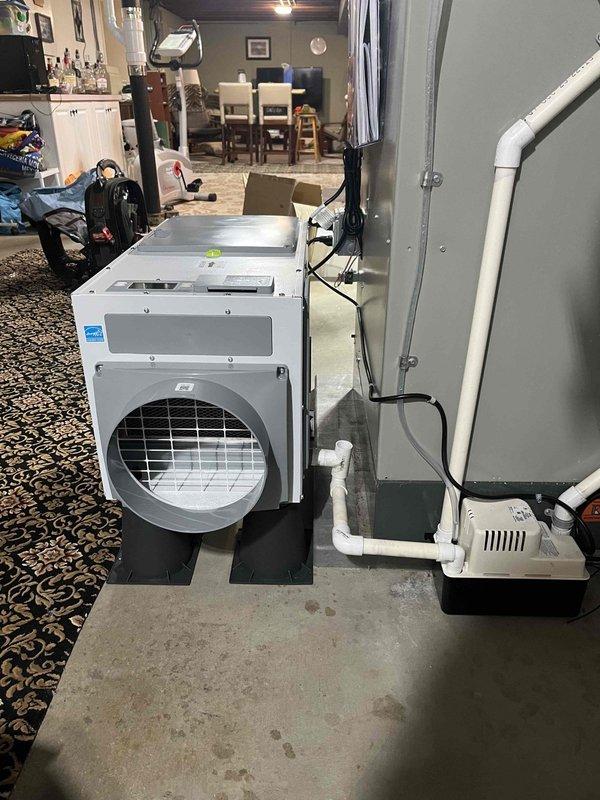 Returned to property to complete dehumidifier installation estimate and site assessment. Evaluated existing HVAC system configuration in basement utility area, including furnace with humidifier attachment and current ductwork layout. Assessed installation location for whole-home dehumidifier unit on concrete floor adjacent to existing heating equipment. Verified adequate space for equipment placement, electrical requirements, condensate drainage routing via existing PVC plumbing, and integration points with current HVAC system. Documented equipment positioning on rubber isolation pads, proximity to electrical panel and water heater, and accessibility for future maintenance. Material order placed through supplier for approved installation.