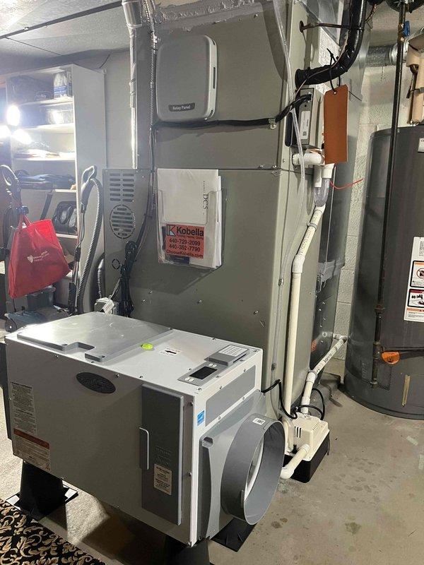 Returned to property to complete dehumidifier installation estimate and site assessment. Evaluated existing HVAC system configuration in basement utility area, including furnace with humidifier attachment and current ductwork layout. Assessed installation location for whole-home dehumidifier unit on concrete floor adjacent to existing heating equipment. Verified adequate space for equipment placement, electrical requirements, condensate drainage routing via existing PVC plumbing, and integration points with current HVAC system. Documented equipment positioning on rubber isolation pads, proximity to electrical panel and water heater, and accessibility for future maintenance. Material order placed through supplier for approved installation.