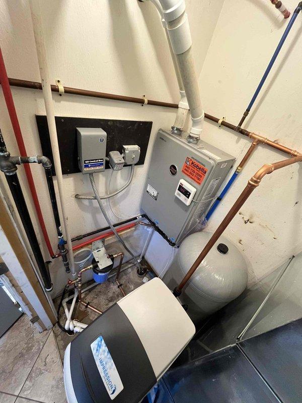 Completed follow-up service for water softener system, pressure tank, and sediment filter installation previously sold. Inspected and verified proper operation of mechanical room equipment including water treatment system with black and white filter housing, gray cylindrical pressure tank, and associated plumbing connections. Confirmed all copper, PEX, and PVC piping connections are secure and functioning correctly with no visible leaks. System is operating as designed with proper water flow and filtration.