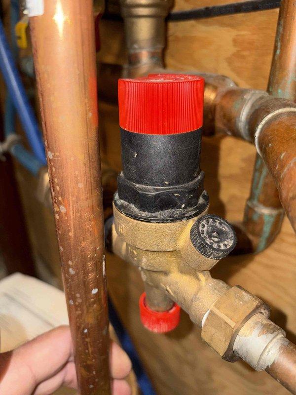 Responded to service call for inoperative floor heating system. Upon inspection, discovered severe frozen condensation and ice buildup on copper supply piping in crawl space, indicating loss of heat circulation to radiant floor heating loops. Frozen conditions on copper lines prevented proper water flow through the system, causing complete heating failure. Inspected pressure relief valve and associated plumbing connections, which showed normal condition with no visible leaks or mechanical defects. System shutdown was determined to be caused by inadequate insulation on supply lines in unconditioned space, allowing pipes to freeze during cold weather conditions. Documented frozen pipe conditions with photographic evidence showing extensive ice formation on copper piping and surrounding components. Advised that pipes will require thawing and proper insulation installation on all exposed copper lines in crawl space to prevent recurrence and restore system operation.
