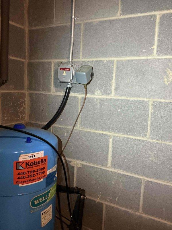 Responded to service call for leaking well tank fitting on recently installed pressure tank system. Upon inspection, identified active leak at brass fitting connection at base of well pressure tank. Tightened fitting connection and verified seal integrity. Tested system operation and confirmed leak was resolved with no further water discharge observed at fitting location.