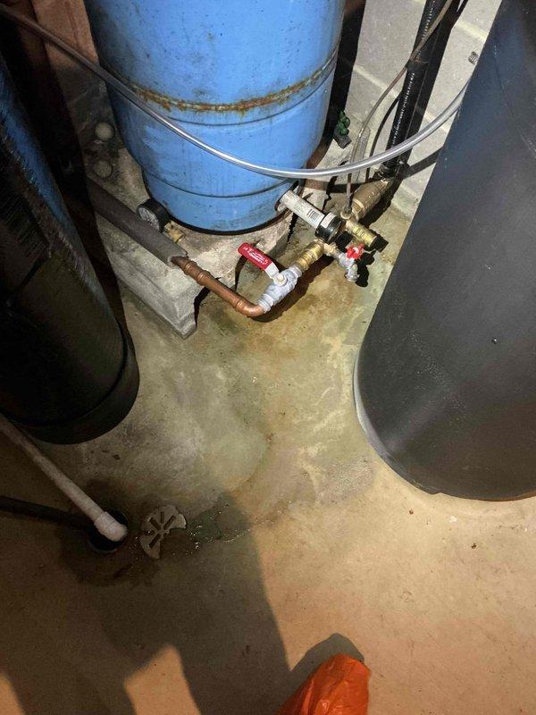Responded to service call for leaking well tank fitting on recently installed pressure tank system. Upon inspection, identified active leak at brass fitting connection at base of well pressure tank. Tightened fitting connection and verified seal integrity. Tested system operation and confirmed leak was resolved with no further water discharge observed at fitting location.
