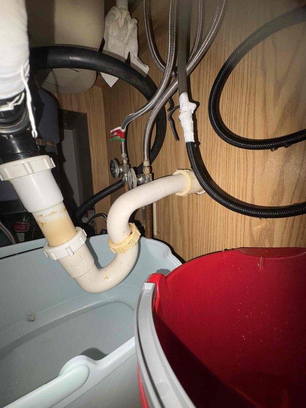 Responded to service call for kitchen sink sprayer repair where homeowner's DIY installation attempt resulted in a leaking hose connection. Assessed existing double-basin stainless steel sink with standard faucet assembly and inspected under-sink plumbing configuration including P-trap, supply lines, and shut-off valves. Provided estimate for proper installation and repair of replacement sprayer assembly, and furnished separate quote for future replacement of existing sink with new 32x22 stainless steel drop-in single basin unit including compatible single-handle faucet with integrated sprayer.