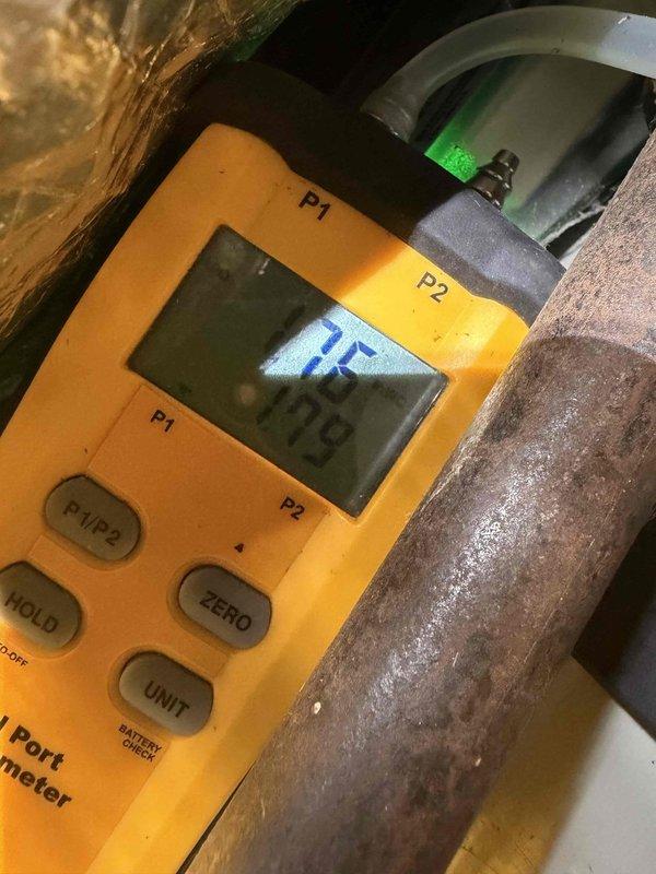 Completed heating maintenance club visit and performed comprehensive system diagnostics. Used Fieldport digital manometer to measure static pressures at supply and return plenums, recording readings of 0.336 and 0.343 inches water column to verify proper airflow and system performance. Inspected condensate drainage system and copper refrigerant lines, noting normal moisture accumulation on suction line indicating proper system operation during heating cycle.