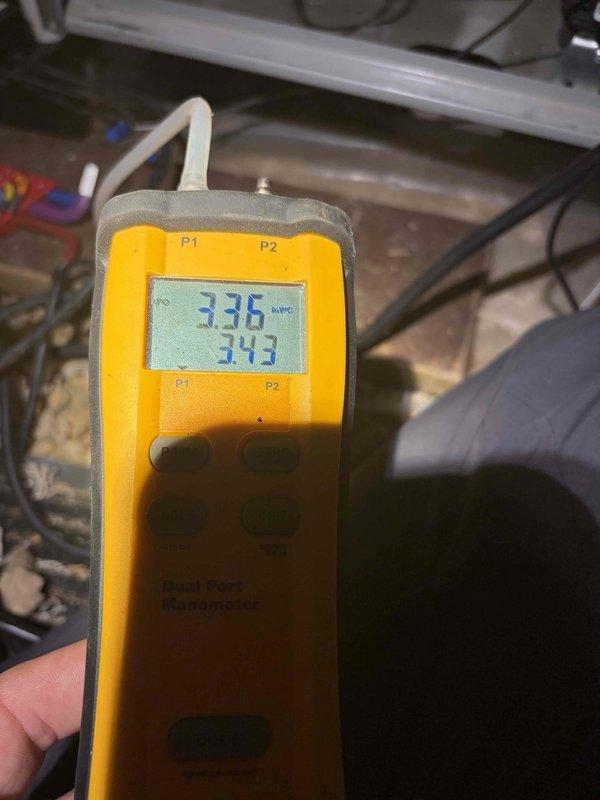 Completed heating maintenance club visit and performed comprehensive system diagnostics. Used Fieldport digital manometer to measure static pressures at supply and return plenums, recording readings of 0.336 and 0.343 inches water column to verify proper airflow and system performance. Inspected condensate drainage system and copper refrigerant lines, noting normal moisture accumulation on suction line indicating proper system operation during heating cycle.