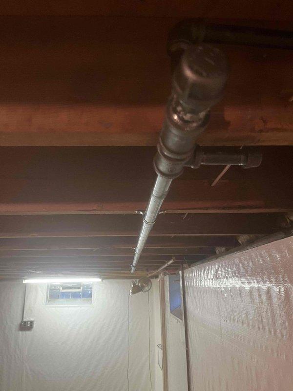 Installed new gas line system with pounds-to-ounce pressure regulator at residential property. Excavation work was coordinated with utility locating services (OUPS ticket #2627101937-000) to safely expose and route the gas supply line to the house. The installation included running black iron pipe through the basement area with proper mounting brackets secured to floor joists, connecting to the pressure regulator system that steps down gas pressure from distribution levels to appliance-safe levels. All work was completed in accordance with local gas code requirements and utility safety protocols.