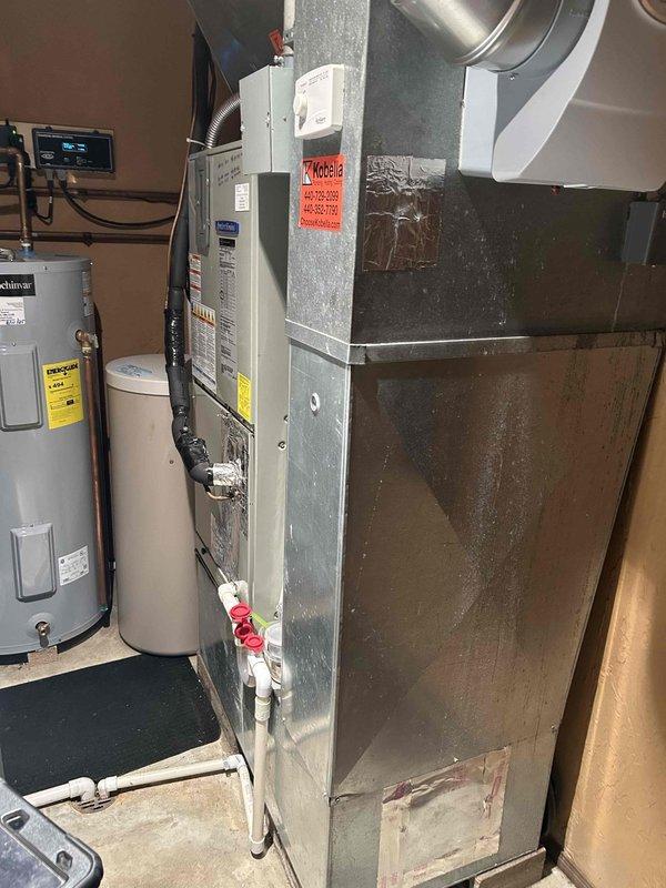 Responded to emergency no-heat call for four-year-old heat pump system. Upon arrival, performed diagnostic testing of the HVAC unit located in basement mechanical room. Utilized digital multimeter to measure electrical readings and verify proper voltage supply to system components. Reading of 2.68 displayed on meter during troubleshooting process indicated potential issue with electrical circuit or component performance. Inspected furnace/air handler unit, noting normal wear and dust accumulation consistent with four years of operation. Examined ductwork connections, thermostat operation, and associated plumbing lines. Documented equipment condition through photography for service records. System evaluated for proper operation of heat pump components and auxiliary heating elements.