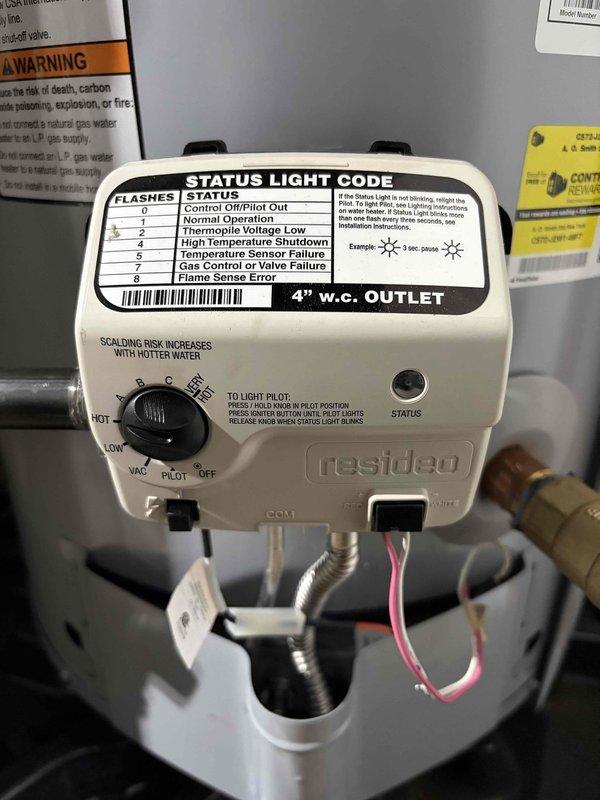 Responded to emergency call for leaking hot water tank. Upon arrival, inspected A.O. Smith ProLine gas water heater with Resideo gas control valve and found active leak from aging unit. Documented equipment condition including control settings, safety labels, and installation configuration with drain pan present. Assessed water heater age and operational status, noting tank deterioration requiring replacement recommendation.