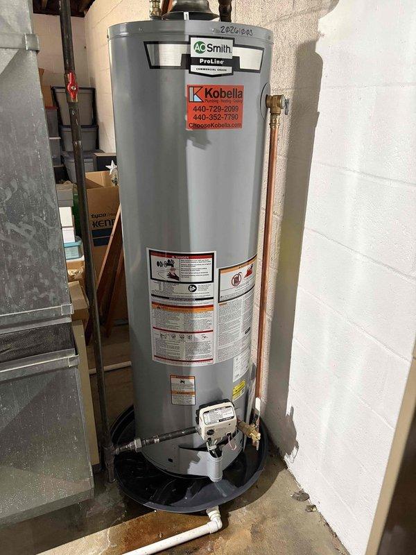 Responded to emergency call for leaking hot water tank. Upon arrival, inspected A.O. Smith ProLine gas water heater with Resideo gas control valve and found active leak from aging unit. Documented equipment condition including control settings, safety labels, and installation configuration with drain pan present. Assessed water heater age and operational status, noting tank deterioration requiring replacement recommendation.