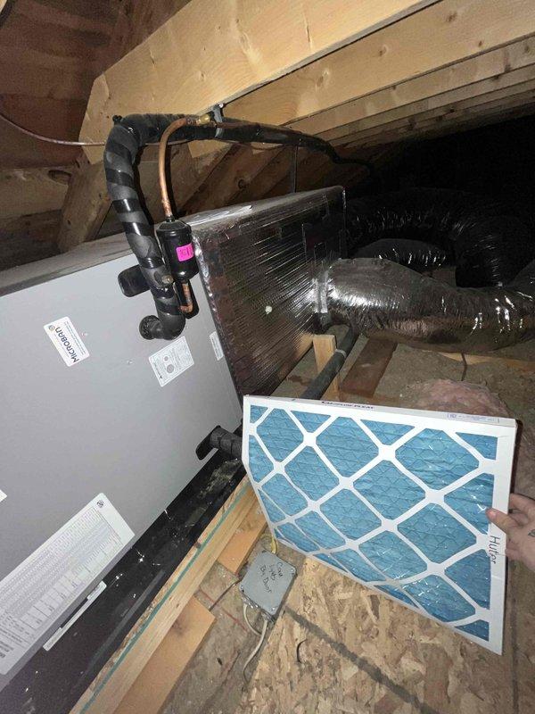 Completed comprehensive maintenance on combi boiler system located in attic space. Performed standard club membership maintenance procedures including system inspection, filter evaluation, and operational checks. Relocated air filtration system as requested, repositioning filters from original location to improve accessibility for future maintenance. Documented existing copper refrigerant line corrosion on lower pipe assembly showing significant verdigris buildup requiring monitoring. Inspected air handler unit, ductwork connections, and evaporator coil assembly—all components found operating within normal parameters. System left in proper working condition with improved filter access for homeowner maintenance.