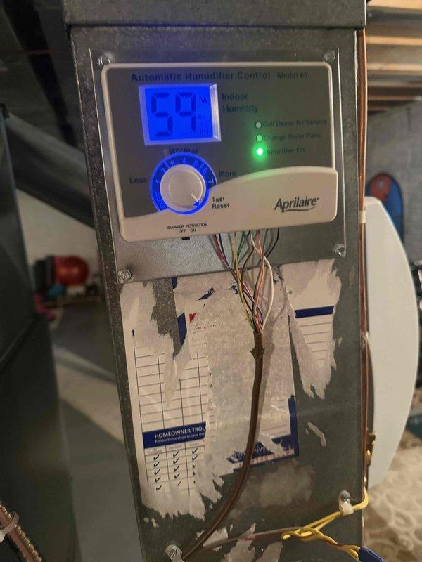 Replaced air filter in air purification system due to excessive dust accumulation and discoloration affecting filtration efficiency. Verified Aprilaire humidifier control unit operation and proper outdoor humidity sensor functionality with digital display readings within normal parameters.